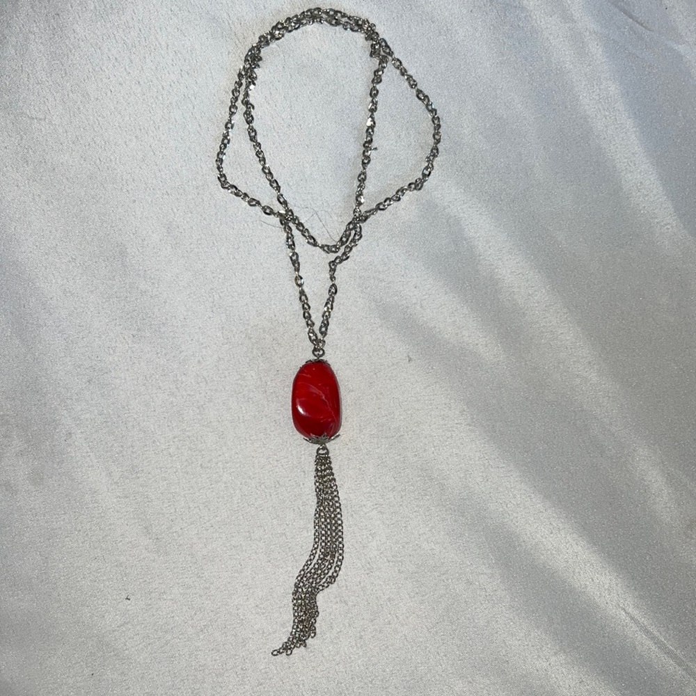 Long silver tone necklace with red stone
